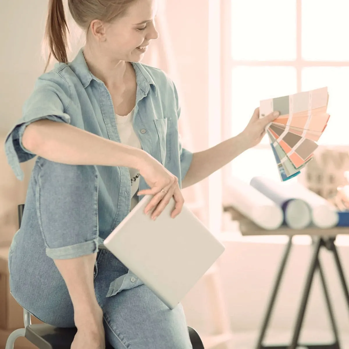 Woman holding paint colour swatches in her new home